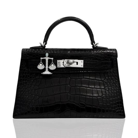 Black crocodile skin handbag with silver hardware on a white background, collection-preview