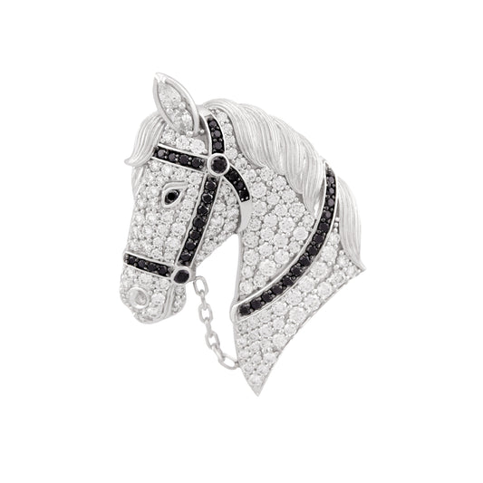 Jewelry item resembling a horse head with black and white stones on a white background