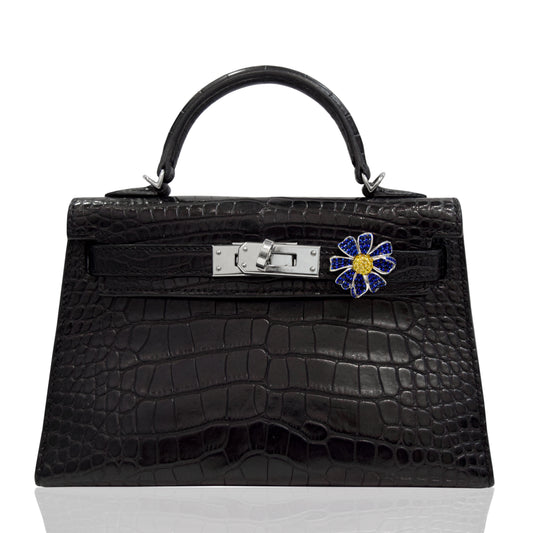Black crocodile skin handbag with a decorative clasp on a white background, collection-preview