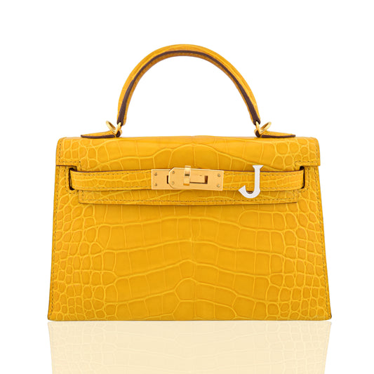 Yellow crocodile-patterned handbag with gold hardware on a white background, collection-preview