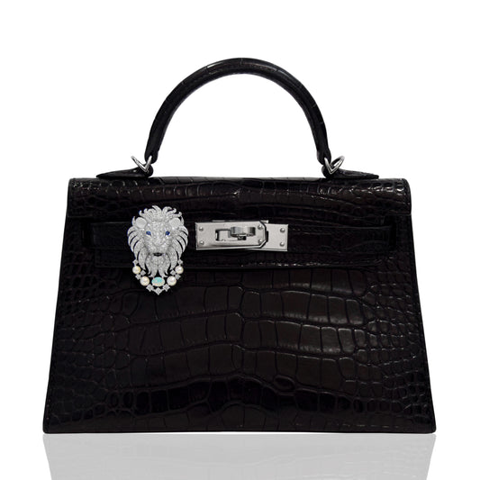 Black crocodile skin handbag with lion head clasp on a white background, collection-preview