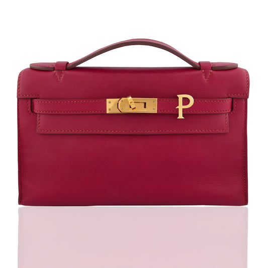 Red handbag with gold clasp on a white background, collection-preview