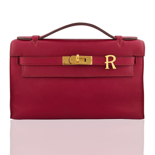 Red handbag with gold clasp and 'R' logo on a white background, collection-preview