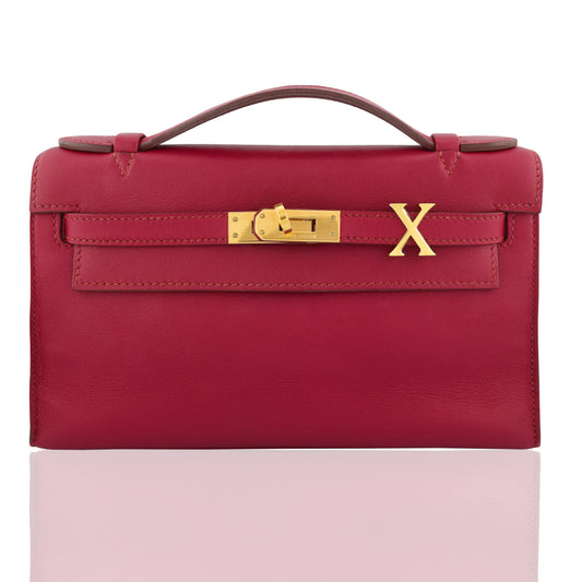 Red handbag with gold clasp and 'X' logo on a white background, collection-preview