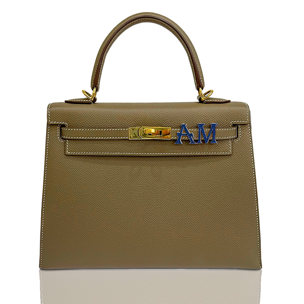Brown handbag with gold hardware and blue letters on a white background, collection-preview