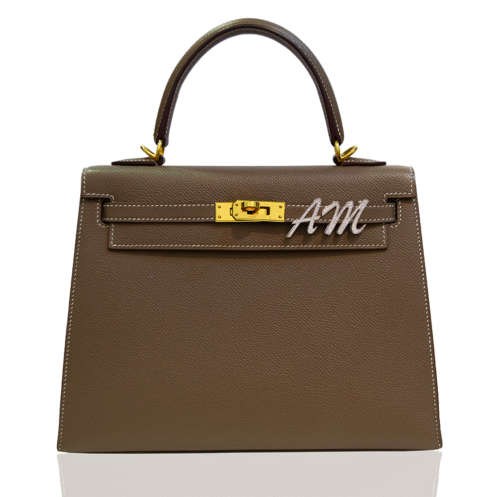 Brown handbag with gold hardware and 'AM' logo on a white background, collection-preview