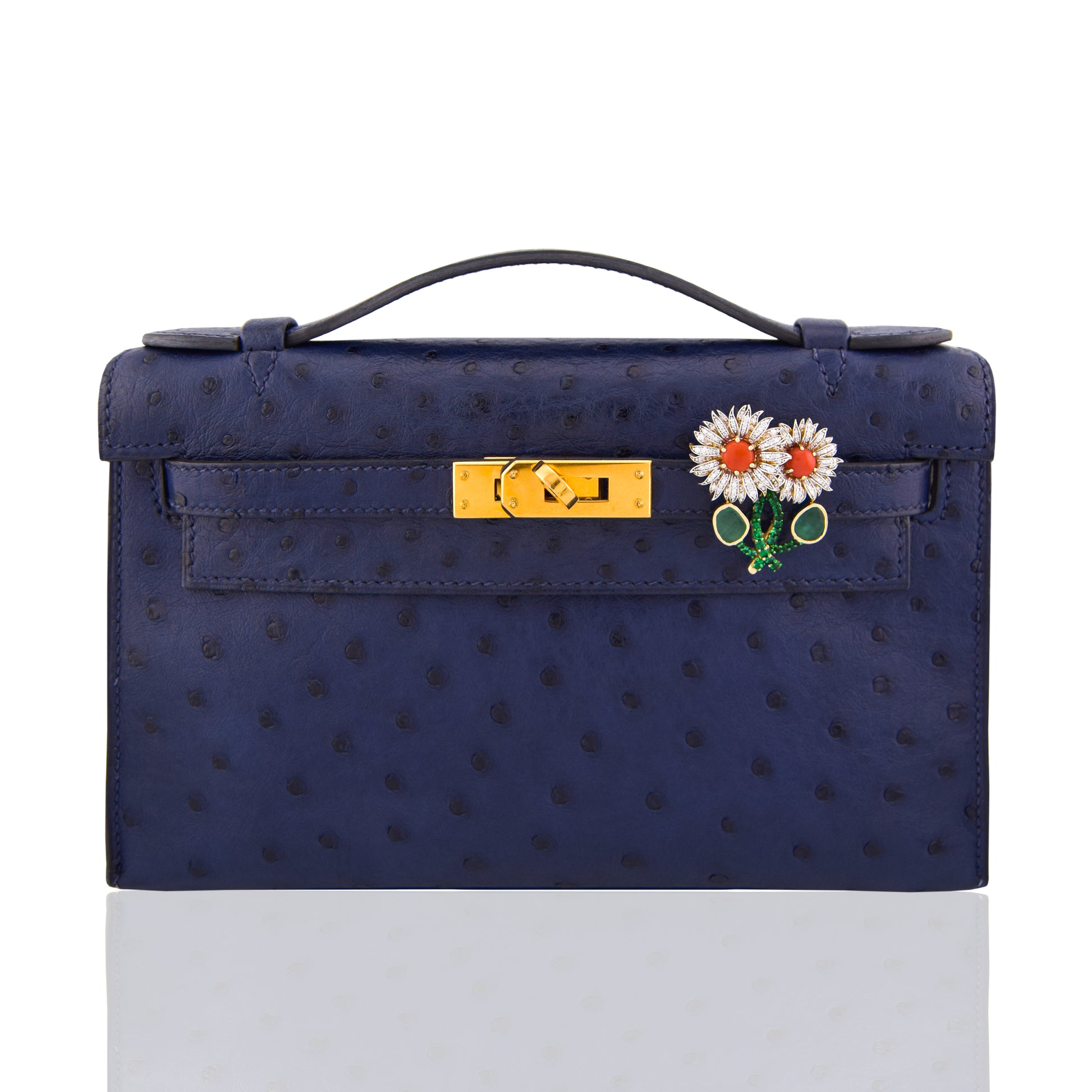 Navy blue handbag with a floral brooch on a white background, collection-preview