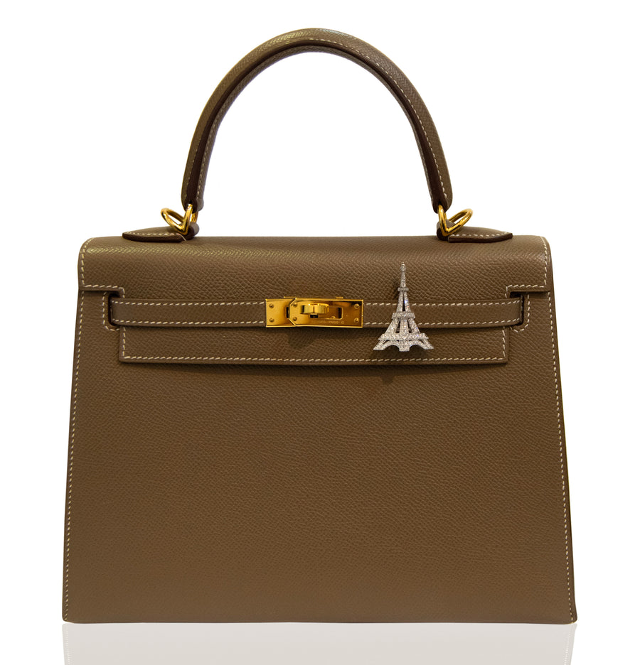Brown handbag with a silver Eiffel Tower charm on a white background, collection-preview