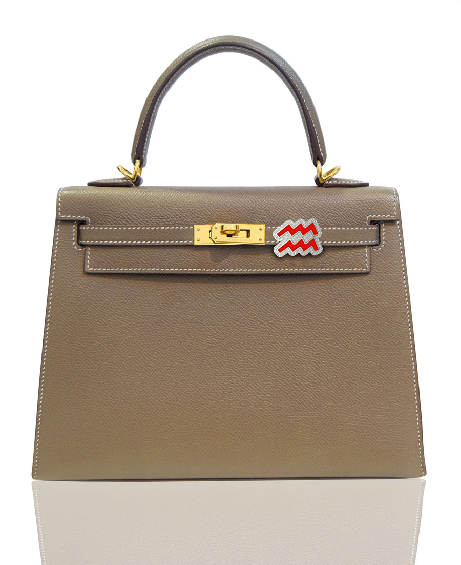 Brown handbag with gold hardware and a red and white tag on a white , collection-previewbackground