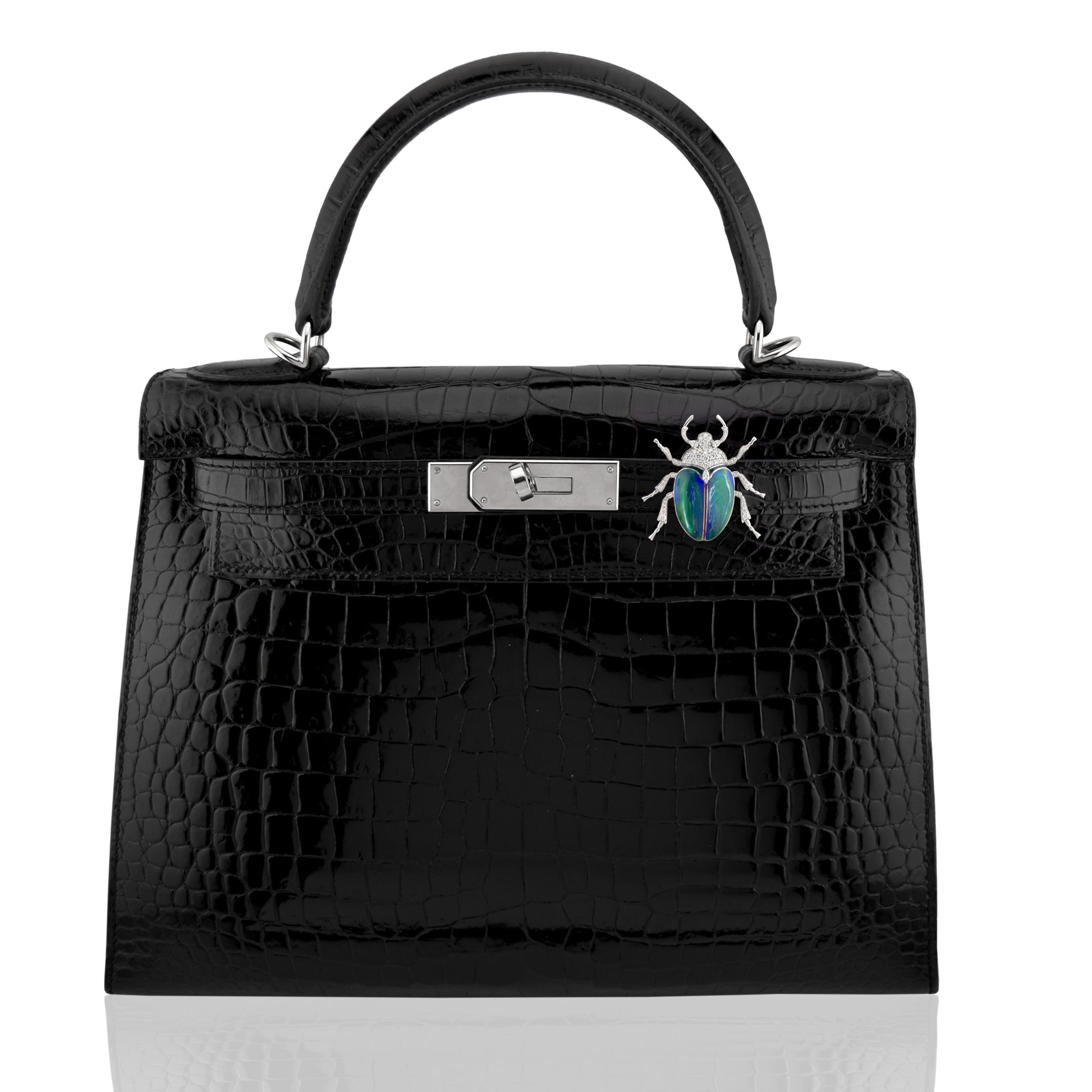 Black crocodile skin handbag with silver hardware and a decorative beetle pin on a white background, collection-preview