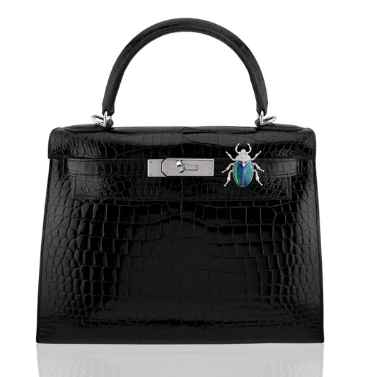 Black crocodile skin handbag with silver hardware and a decorative beetle pin on a white background, collection-preview