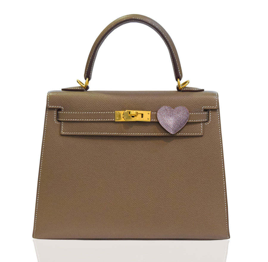 Brown handbag with a heart-shaped clasp on a white background, collection-preview