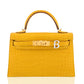 Yellow crocodile skin handbag with gold hardware on a white background, collection-preview