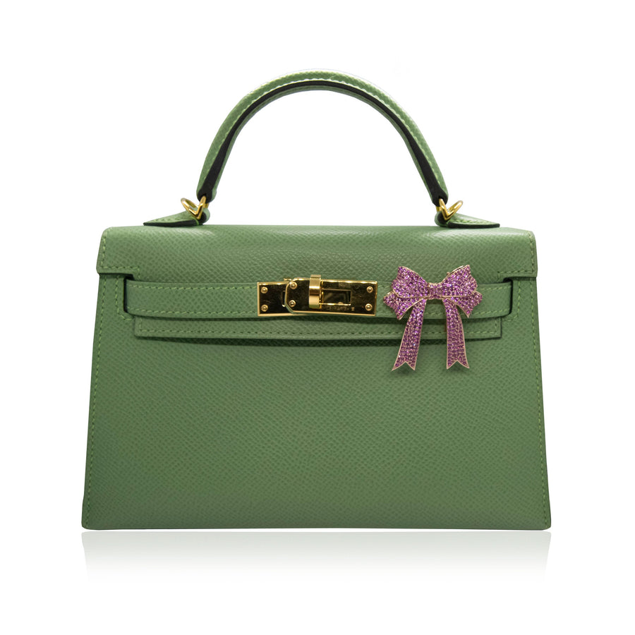 Green handbag with a pink bow on a white background, collection-preview