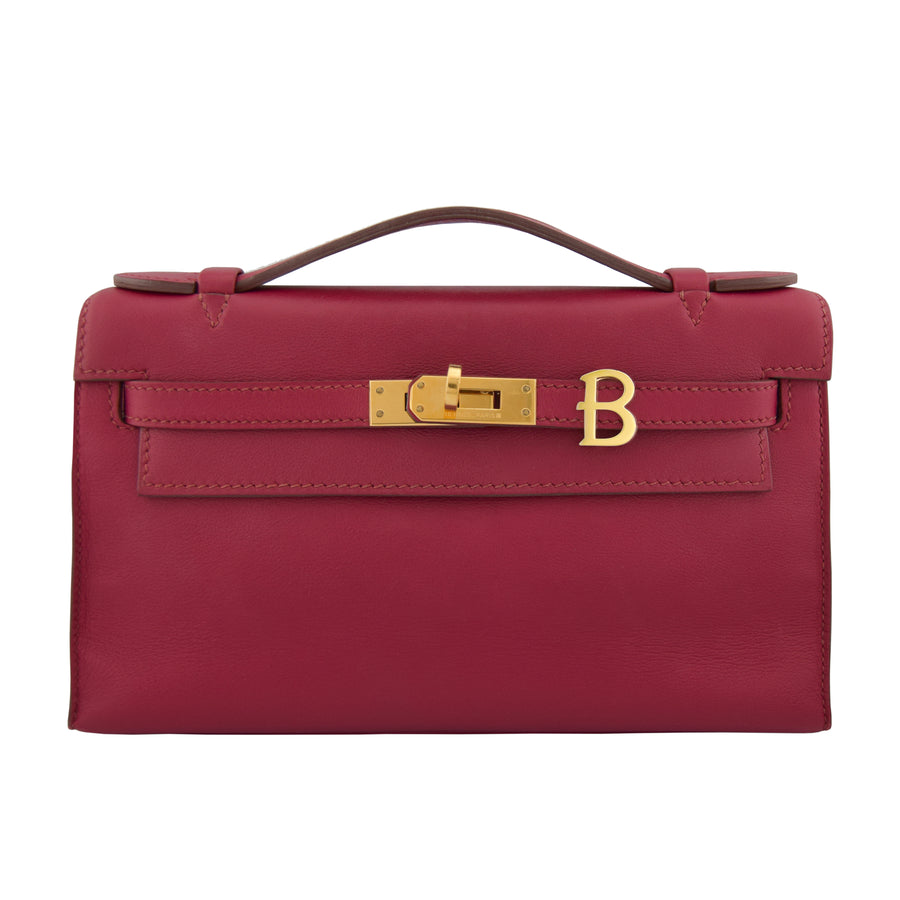 Red handbag with gold clasp on a white background, collection-preview