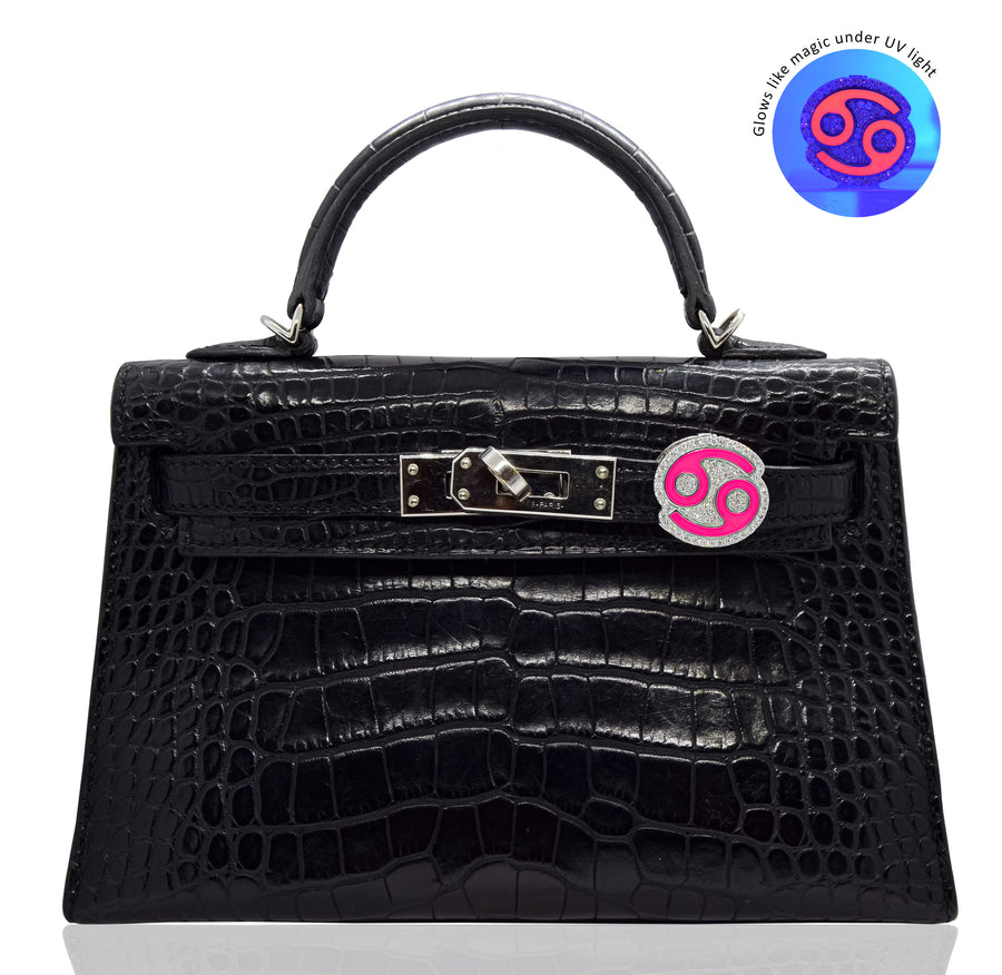 Black crocodile skin handbag with a pink and silver lock on a white background, collection-preview