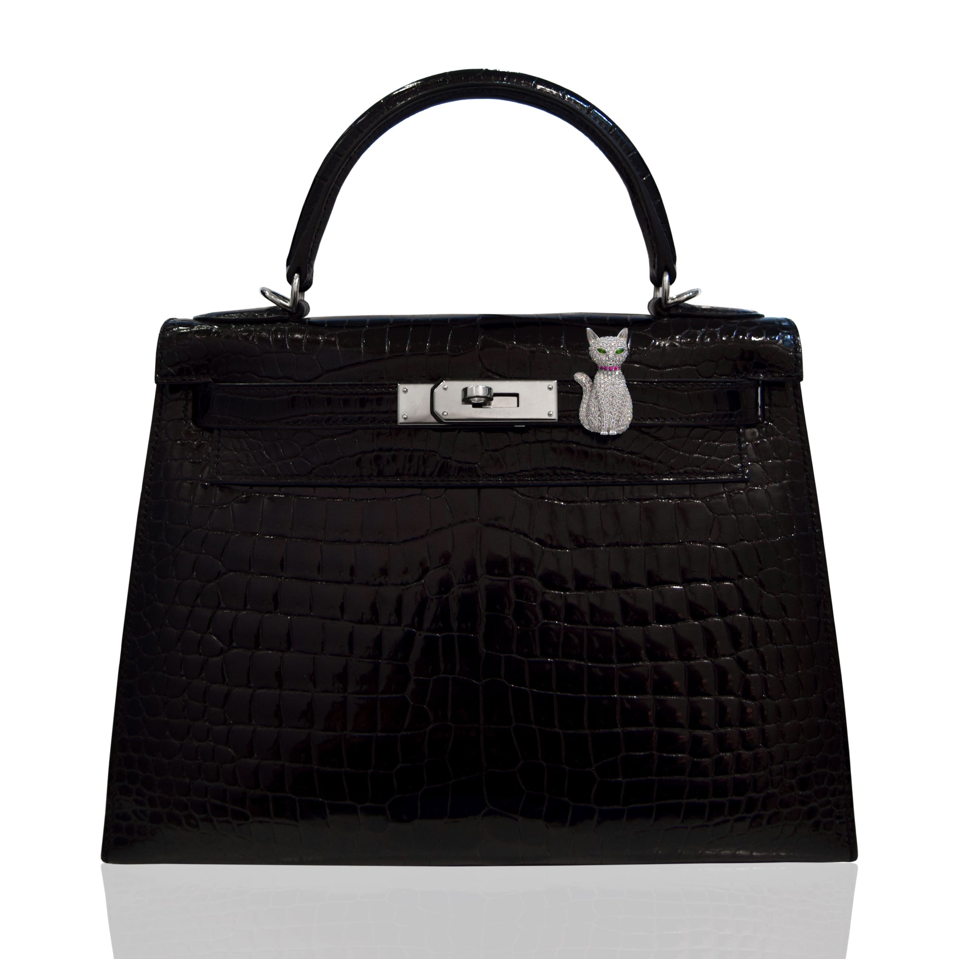 Black textured handbag with a silver clasp and cat charm on a white background, collection-preview