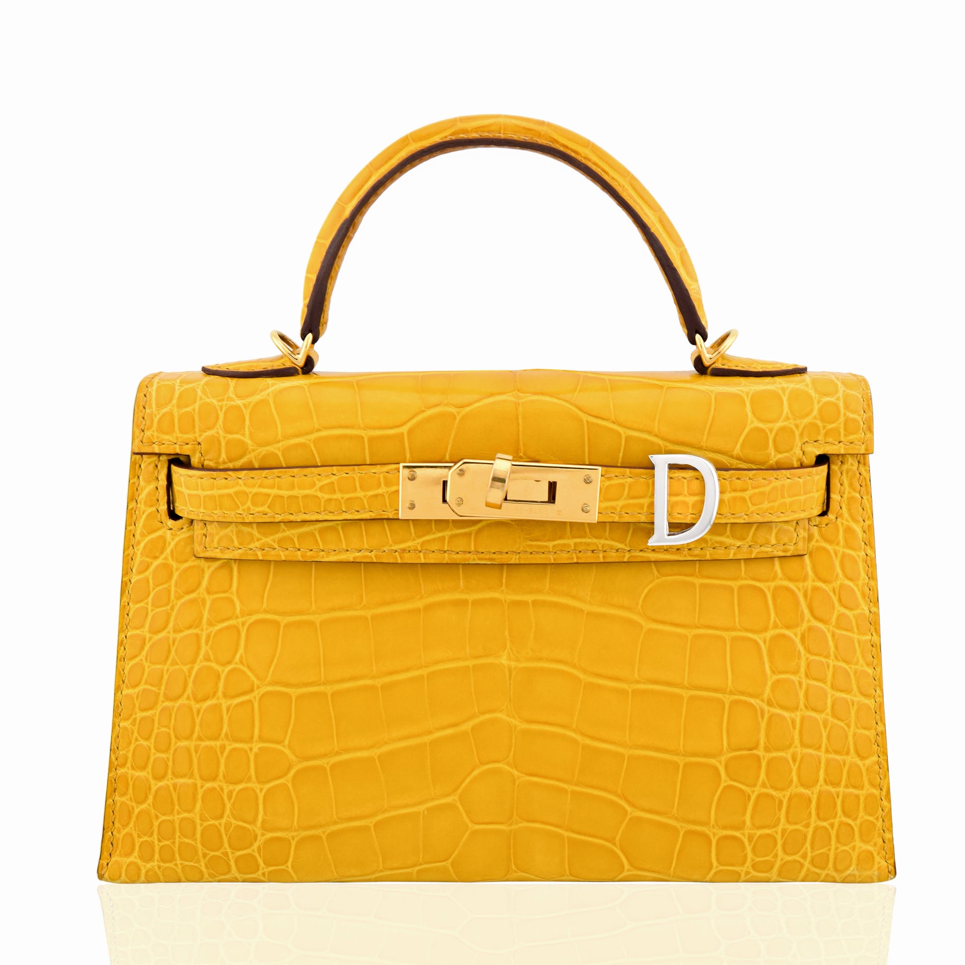 Yellow crocodile skin handbag with gold hardware on a white background, collection-preview