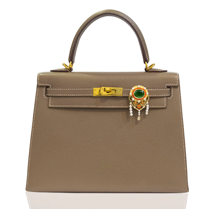 Brown handbag with decorative clasp on a white background, collection-preview