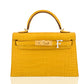 Yellow crocodile skin handbag with gold hardware on a white background, collection-preview