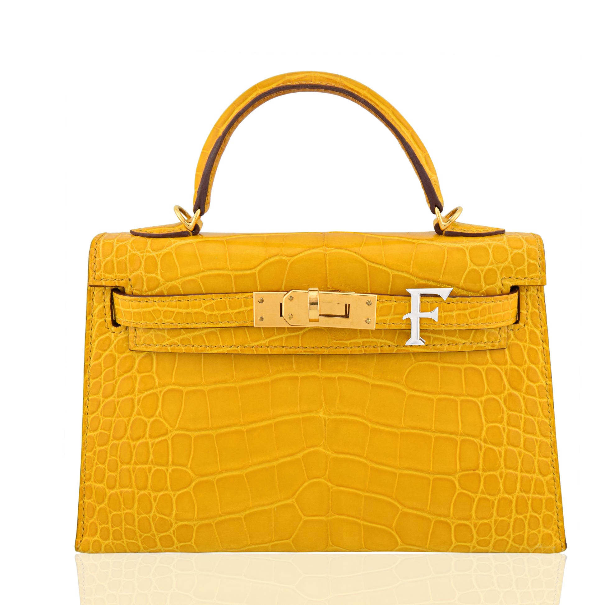 Yellow crocodile skin handbag with gold hardware on a white background, collection-preview