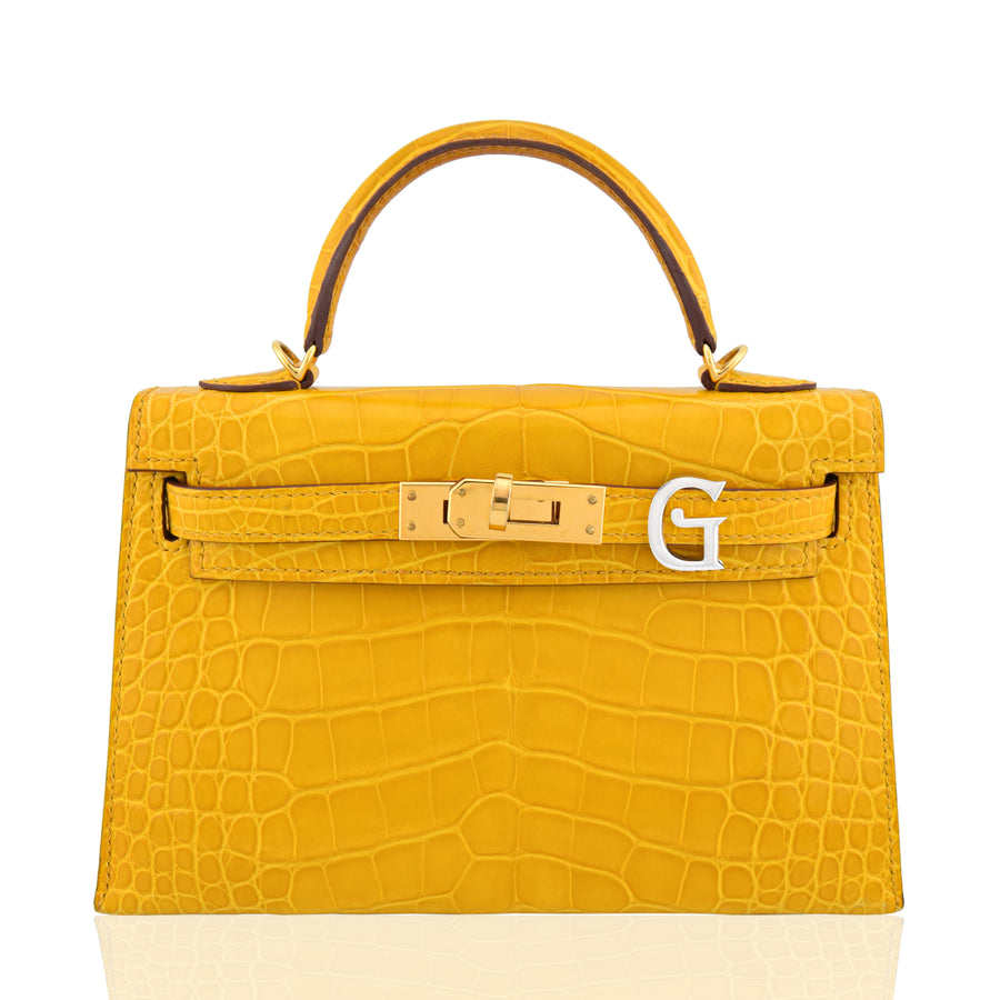 Yellow crocodile-patterned handbag with gold hardware on a white background, collection-preview
