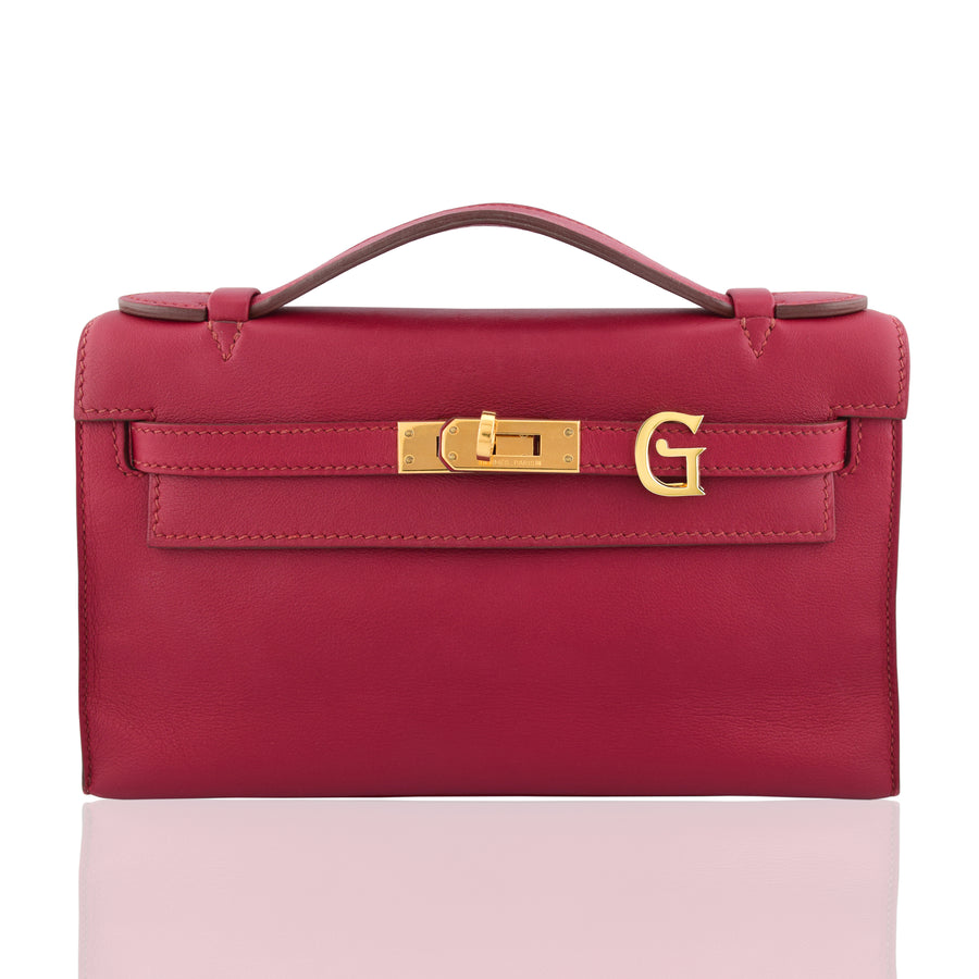 Red handbag with gold clasp on a white background, collection-preview