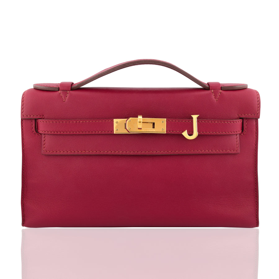 Red handbag with gold clasp on a white background, collection-preview