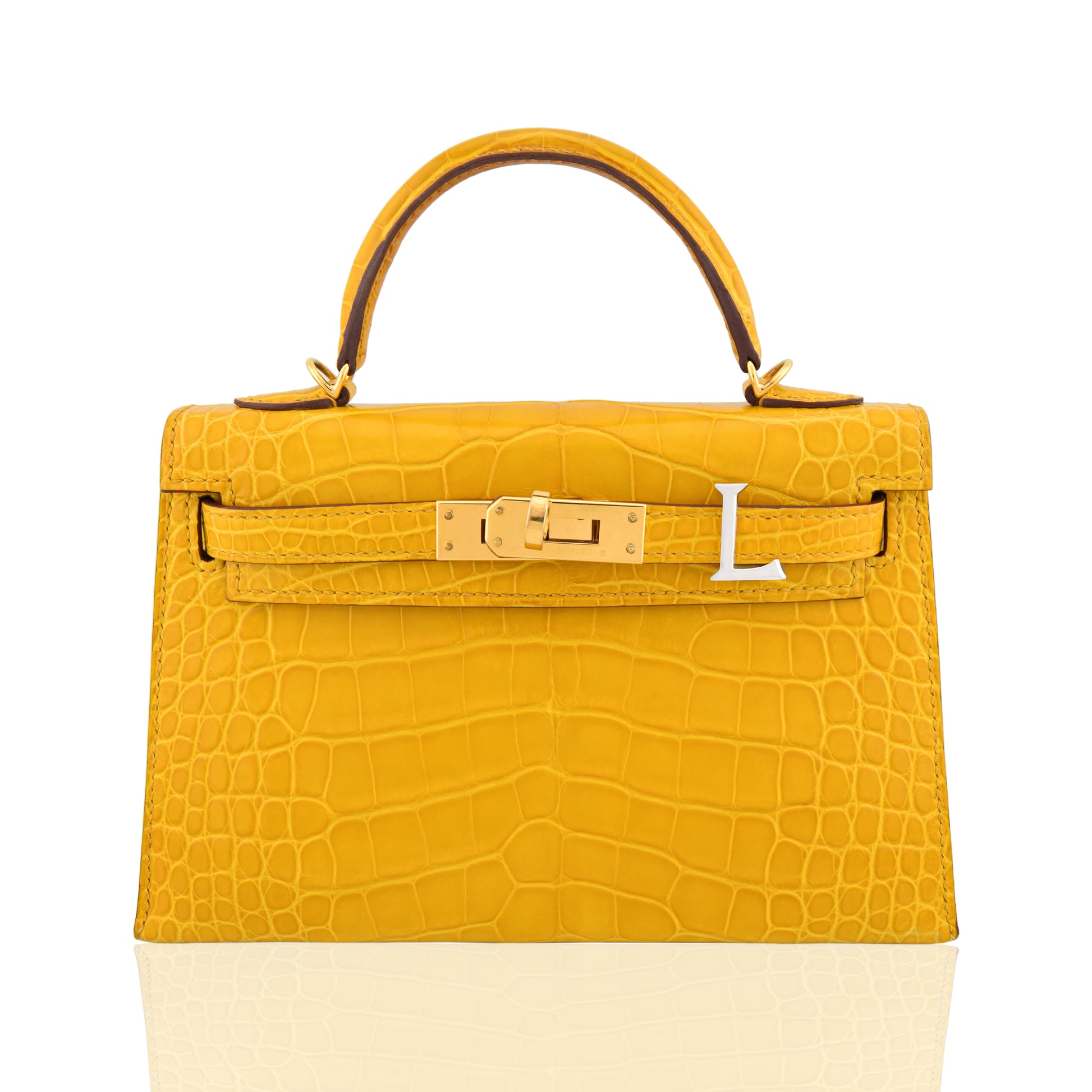 Yellow crocodile skin handbag with gold hardware on a white background, collection-preview