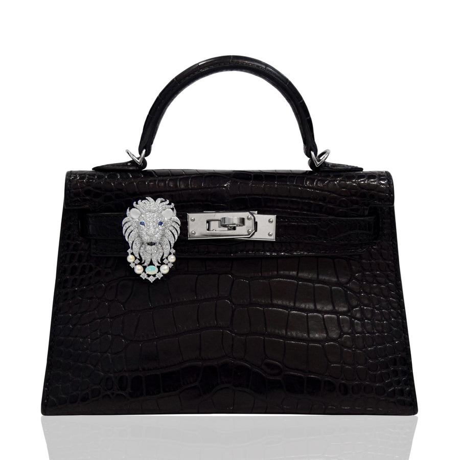 Black crocodile skin handbag with lion head clasp on a white background, collection-preview