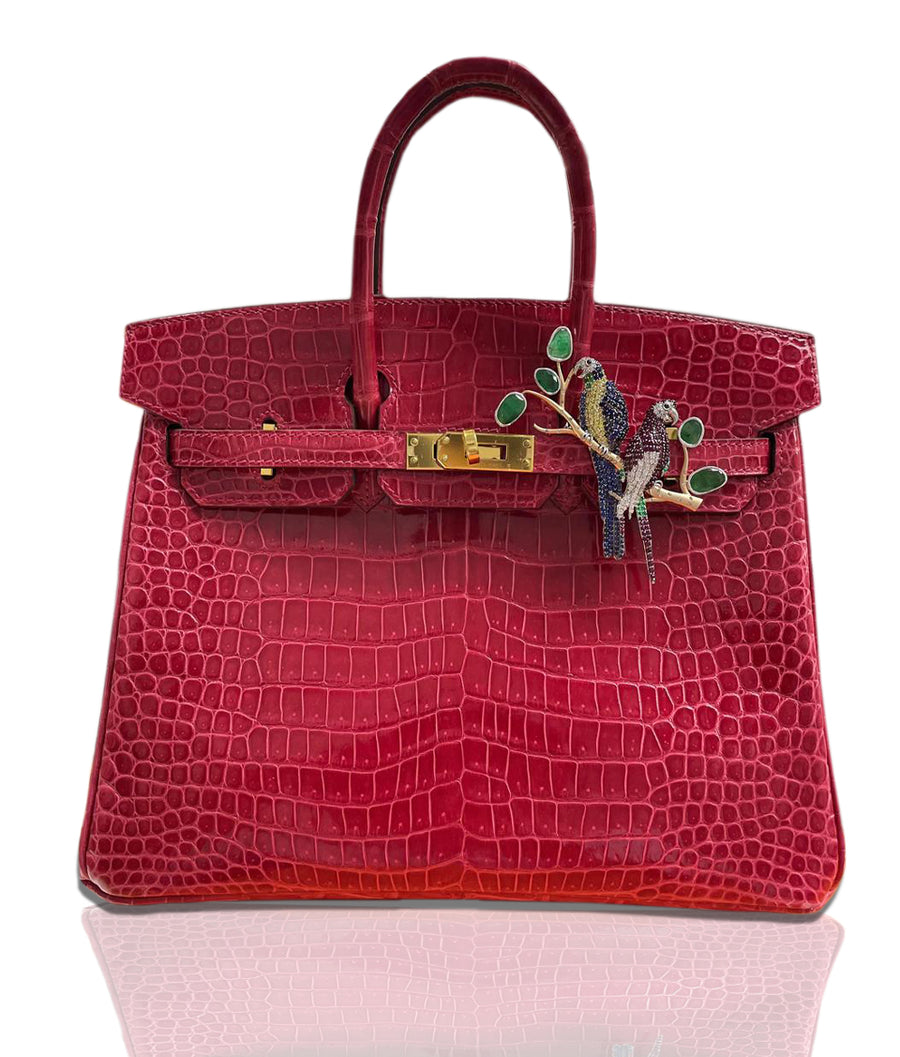 A luxurious red handbag with a crocodile pattern, featuring a gold clasp and a charm with a lovebirds design inlaid with multicolored gemstones, collection-preview.