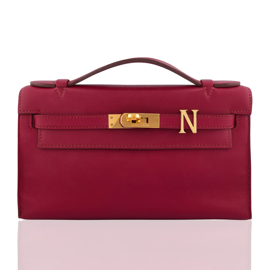 Red handbag with gold clasp and logo on a white background, collection-preview