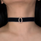 Black choker with a rose gold buckle worn by a person