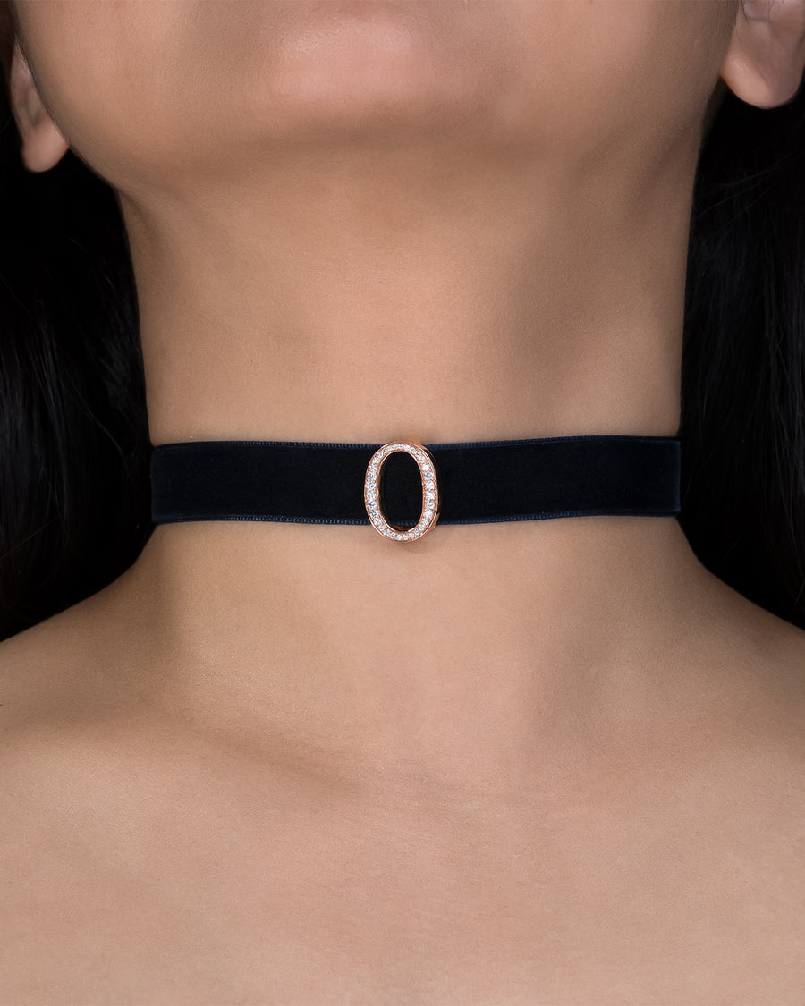 Black choker with a rose gold buckle worn by a person
