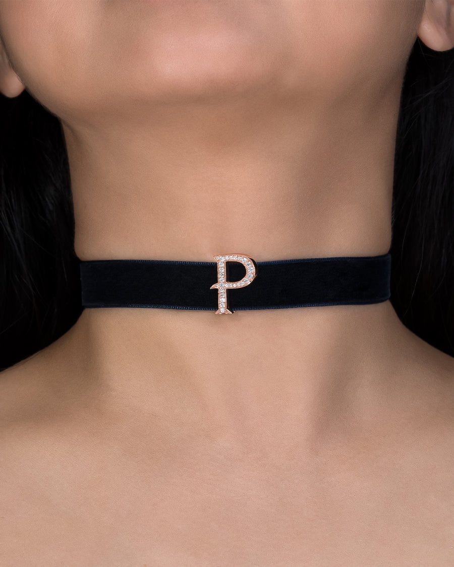 Black choker with a 'P' charm on a person's neck