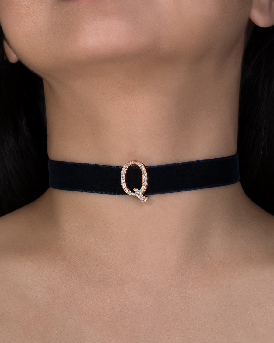 Black choker with a rose gold clasp on a person's neck