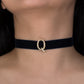 Black choker with a gold clasp worn by a person