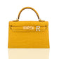 Yellow crocodile-patterned handbag with gold hardware and a white patch on a white background, collection-preview