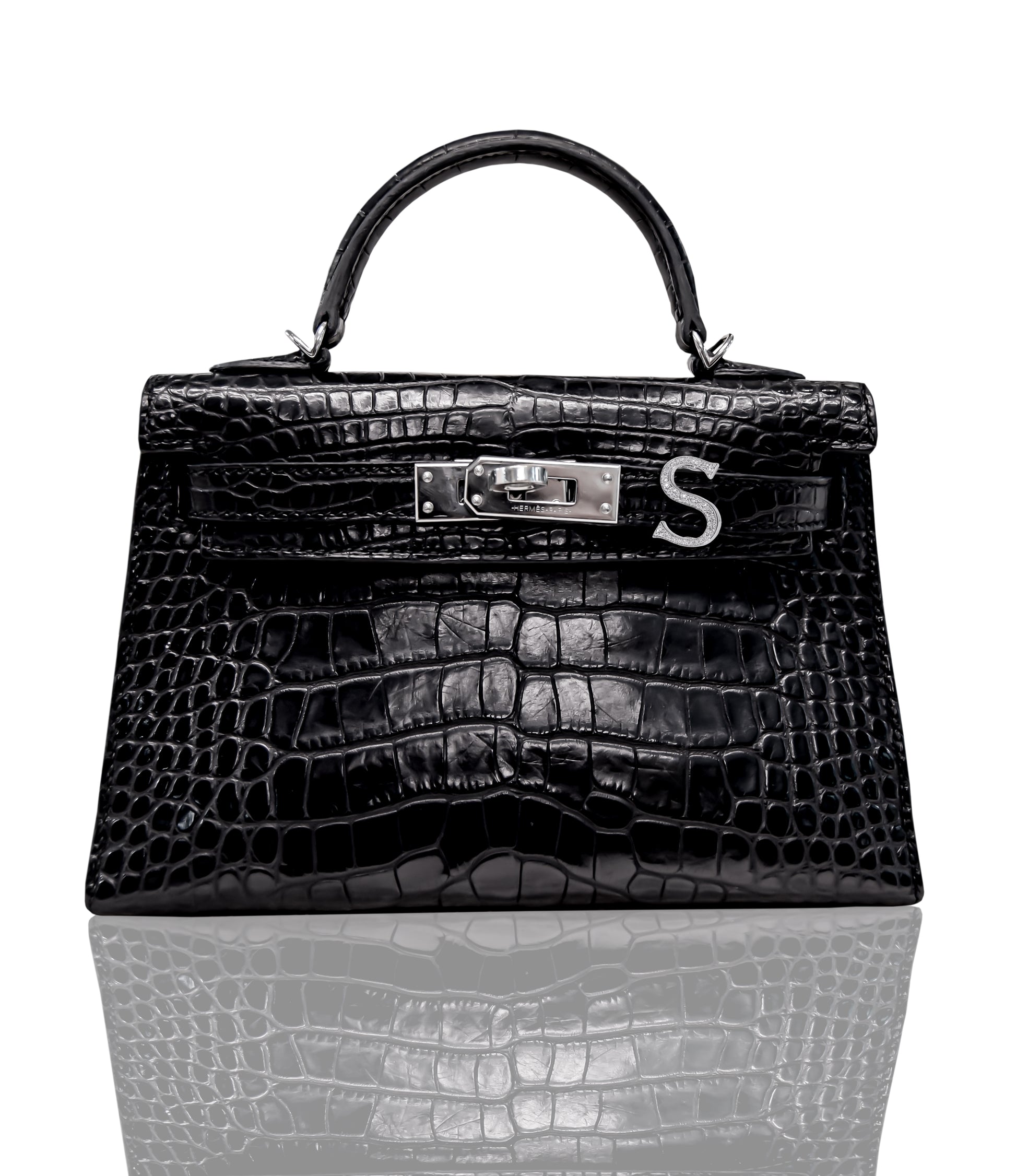 A black handbag with a crocodile pattern featuring a brooch with the letter 'S' and set in white gold, collection-preview.