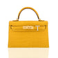 Yellow crocodile skin handbag with gold hardware on a white background, collection-preview