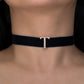 Black choker necklace with a gold clasp on a person's neck