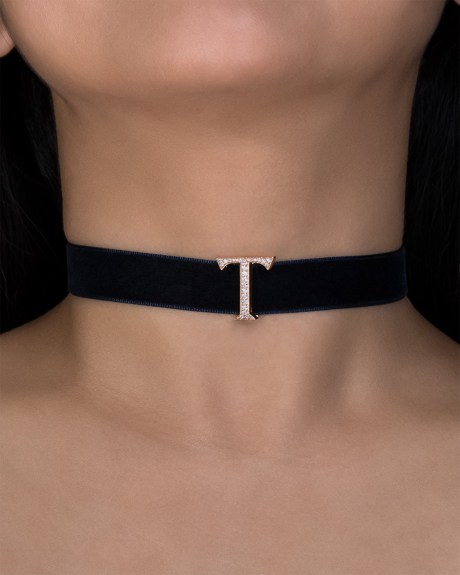Black choker necklace with a gold clasp on a person's neck