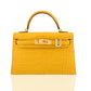 Yellow crocodile skin handbag with gold hardware on a white background, collection-preview