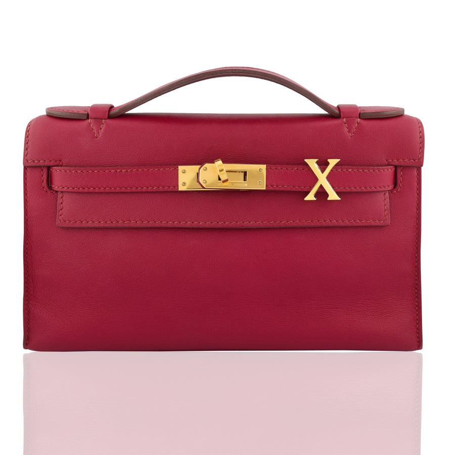 Red handbag with gold clasp and 'X' logo on a white background, collection-preview