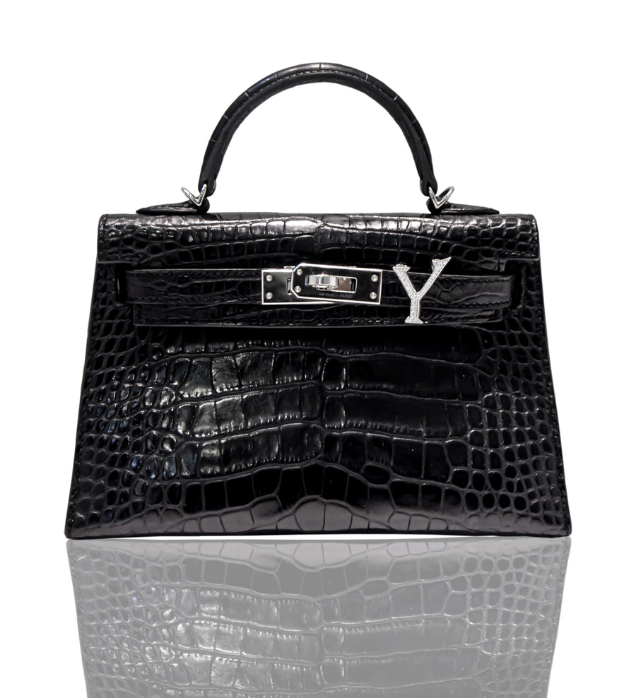 A black handbag with a crocodile pattern and a natural diamond-encrusted 'Y' letter set in a metallic clasp, collection-preview.