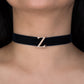 Black choker necklace with a gold 'Z' clasp on a person's neck.