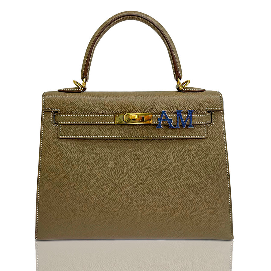 Brown handbag with gold hardware and blue letters on a white background, collection-preview