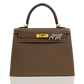 Brown handbag with gold hardware and 'AM' logo on a white background, collection-preview