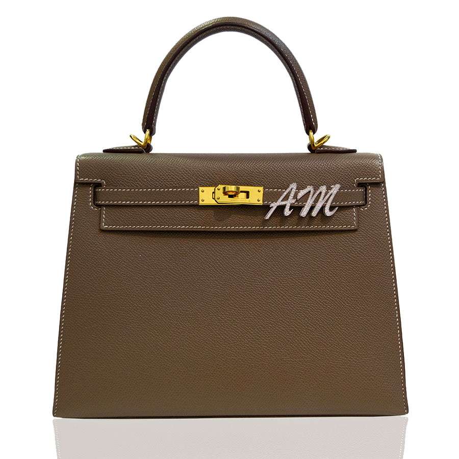 Brown handbag with gold hardware and 'AM' logo on a white background, collection-preview